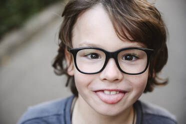 Playful boy wearing eyeglasses sticking out tongue - EYAF02859
