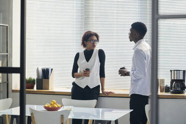 Young businessman having discussion with businesswoman in office - DSHF01068