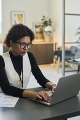 Geschäftsfrau mit Laptop am Schreibtisch im Büro - DSHF01093