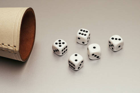 Still life five white dice and leather cup on white background - FSIF06611