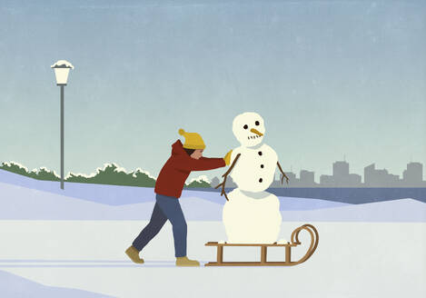 Woman pushing snowman on sled in snowy winter city park - FSIF06642