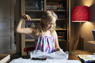 Girl sewing on desk with lamp - FOLF12346