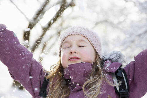 Girl in purple coat under snow - FOLF12351