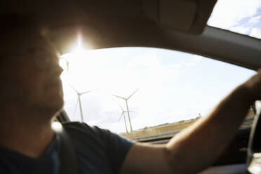 Man driving car by wind farm - FOLF12373