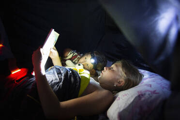 Girls reading at night in tent - FOLF12384