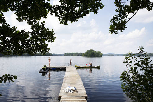 Family with canoe on jetty on Lake Nommen, Sweden - FOLF12386