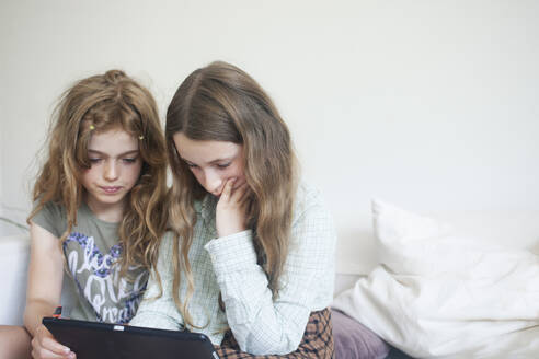 Girls using digital tablet on sofa - FOLF12431