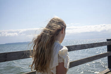 Girl walking by railing at coast - FOLF12433