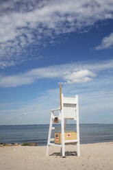 Lifeguard chair under clouds by sea - FOLF12434