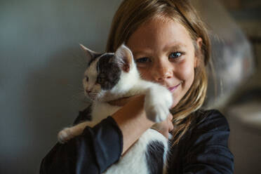 Smiling girl holding pet cat - FOLF12459