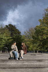 Junge Frauen sitzen im Park - FOLF12489