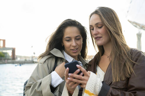 Young women using smartphone by marina - FOLF12499