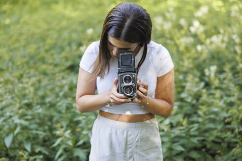 Young woman using vintage camera - FOLF12524