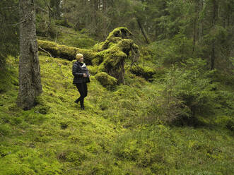 Woman with her daughter hiking in forest - FOLF12531