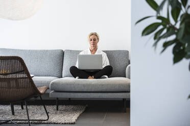 Woman working with laptop in office - FOLF12533