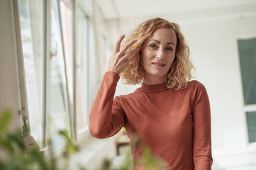 Lächelnde Geschäftsfrau mit blondem Haar im Büro stehend - JOSEF22056