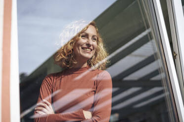 Happy woman seen through glass window - JOSEF22058