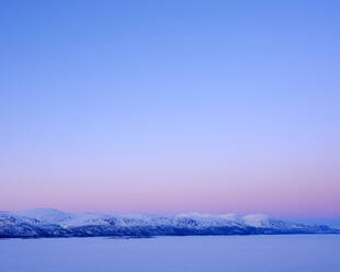 Tornetrask Lake and mountains under snow at sunset in Sweden - FOLF12564