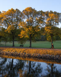 Woman walking on path by river - FOLF12609