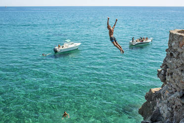 Boy diving into sea from cliff - FOLF12639