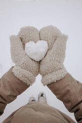 Frau mit Handschuhen und stehend mit herzförmigen Schnee im Winter - VIVF01251