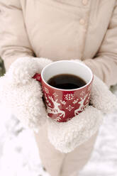 Woman wearing gloves and holding coffee cup - VIVF01256