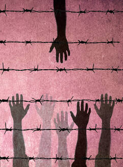 Hands of people reaching towards barbed wire - GWAF00404
