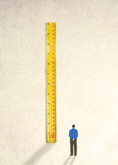 Man looking at oversized ruler - GWAF00409