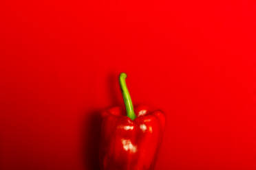 Top view of crop ripe red pepper placed on red background - ADSF49116