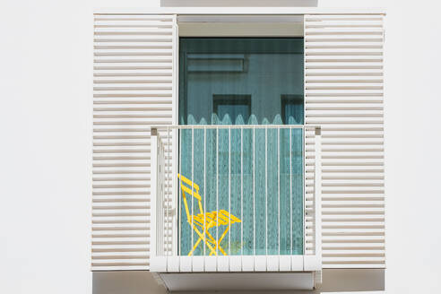 Exterior of a balcony of an Ibizan Mediterranean house with a yellow chair - ADSF49149