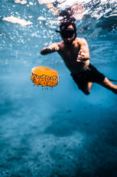 Foto einer Unterwasserszene mit einem Mann, der eine Schnorchelmaske trägt und im kristallklaren Wasser von Menorca schwimmt - ADSF49167