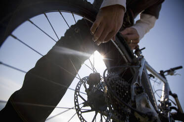 Man hands checking the wheel of a bicycle - FSIF06659