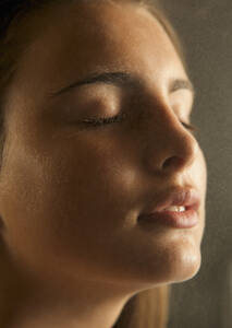 Close up of a young woman face covered in misty water - FSIF06669