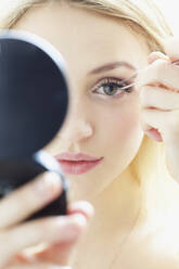 Close up of Young Woman Applying False Eyelashes - FSIF06704