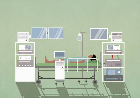 Male patient laying on operating table among technology equipment in operating room - FSIF06790