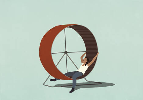 Tired woman laying inside hamster wheel - FSIF06794