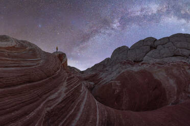 Back view full body of anonymous traveler standing on hill near mountains under starry sky in Utah USA - ADSF49204