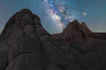 Breathtaking view of arid hills and mountains located against starry sky at dark night in Utah USA - ADSF49206