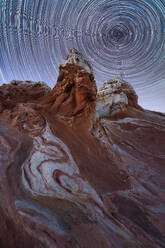 From below of massive rocky formations under starry sky at dark in Utah USA - ADSF49208
