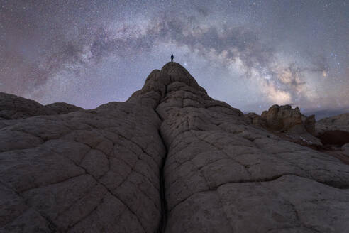 Back view full body of anonymous traveler standing on hill near mountains under starry sky in Utah USA - ADSF49213
