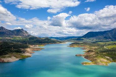 Scenery of green valley with mountains and lake under cloudy sky in Zahara de la Sierra region of Andalusia and water reservoir Spain - ADSF49237