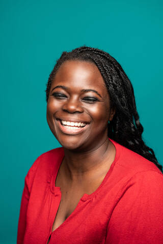 Close up of an African woman in a red blouse smiling warmly with