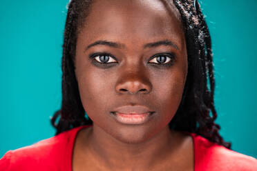 Close-up of an African woman's face showcasing her detailed features, set against a turquoise background - ADSF49287