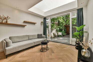 Couch with coffee table next to large window with sliding doors in modern living room at white apartment - ADSF49350