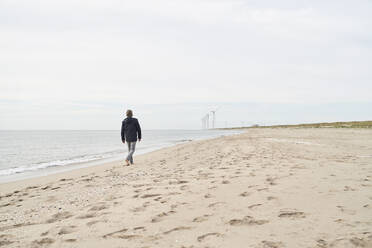 Älterer Mann, der am Strand spazieren geht - PHDF00117
