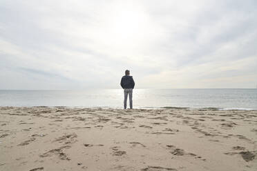 Man standing in front of sea at beach - PHDF00119