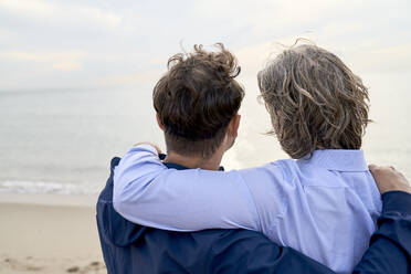 Father and son with arm around at beach - PHDF00134