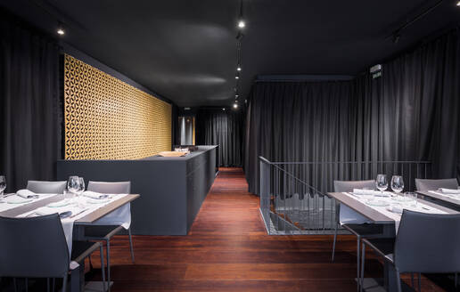 Photo of a spacious dining area with a communal table and comfortable seating in a restaurant - ADSF49451