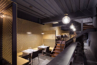 Photo of a spacious dining area with a communal table and comfortable seating in a restaurant - ADSF49452