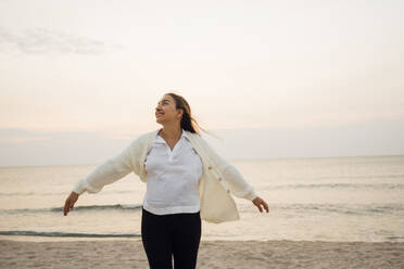 Happy young pregnant woman enjoying at beach - AAZF01241